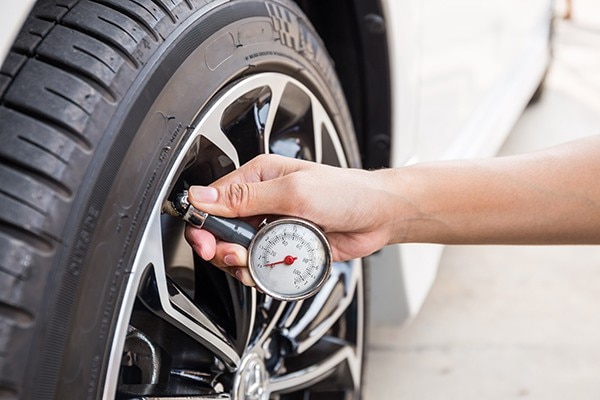 Close-Up Of Hand holding pressure gauge for car tyre pressure measurement; Shutterstock ID 436502665; purchase_order: Fleet - Web; job: ; client: ; other: 